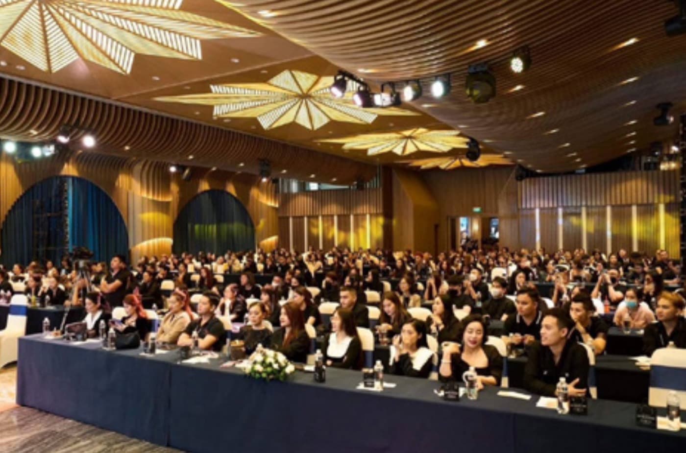 Hội trường workshop kín người ngồi theo dãy bàn dài, sân khấu và màn hình phía trước.